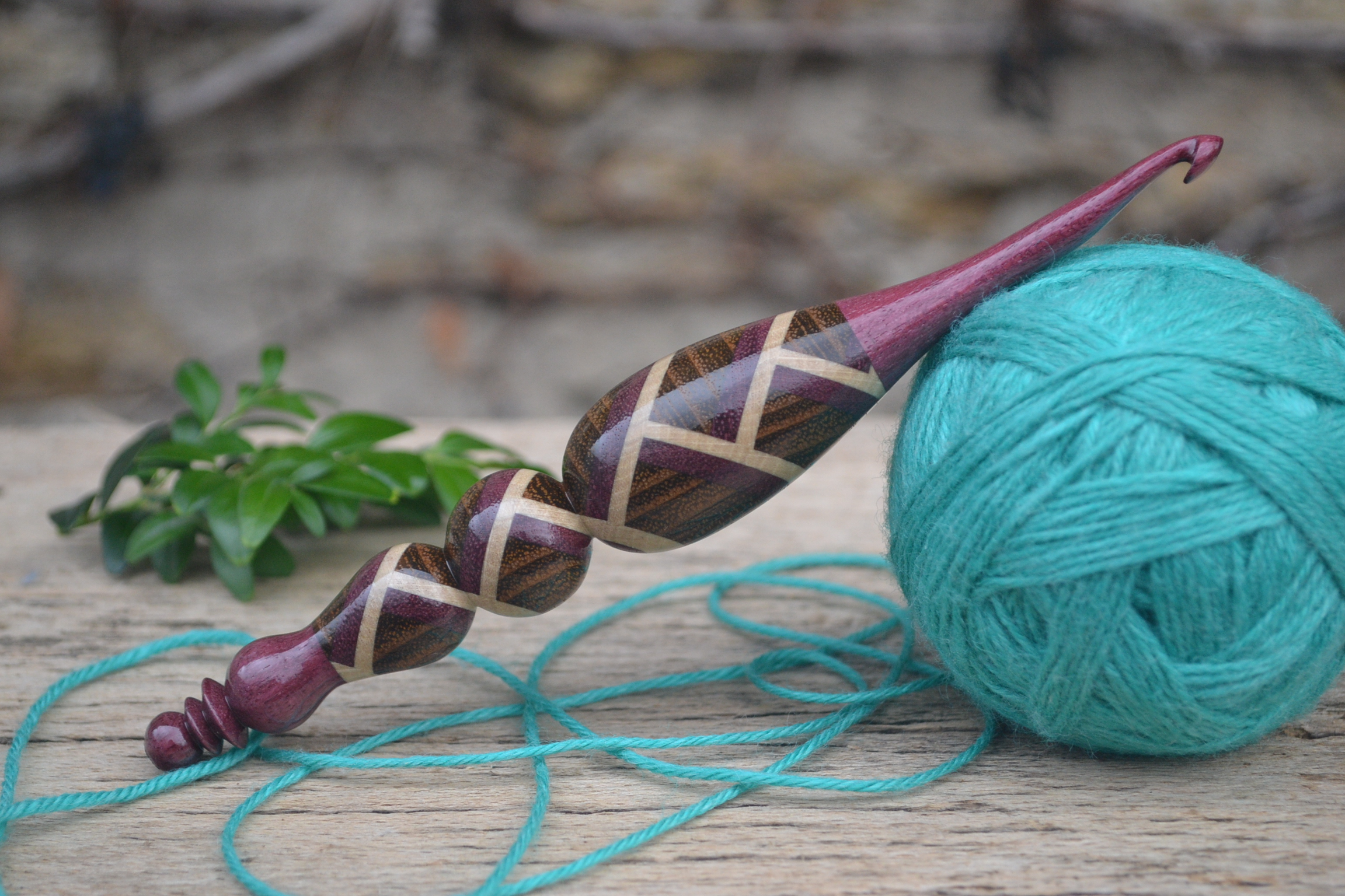 Handmade mosaic crochet hook with an ergonomic design, crafted from amaranth, robinia, and hornbeam wood.