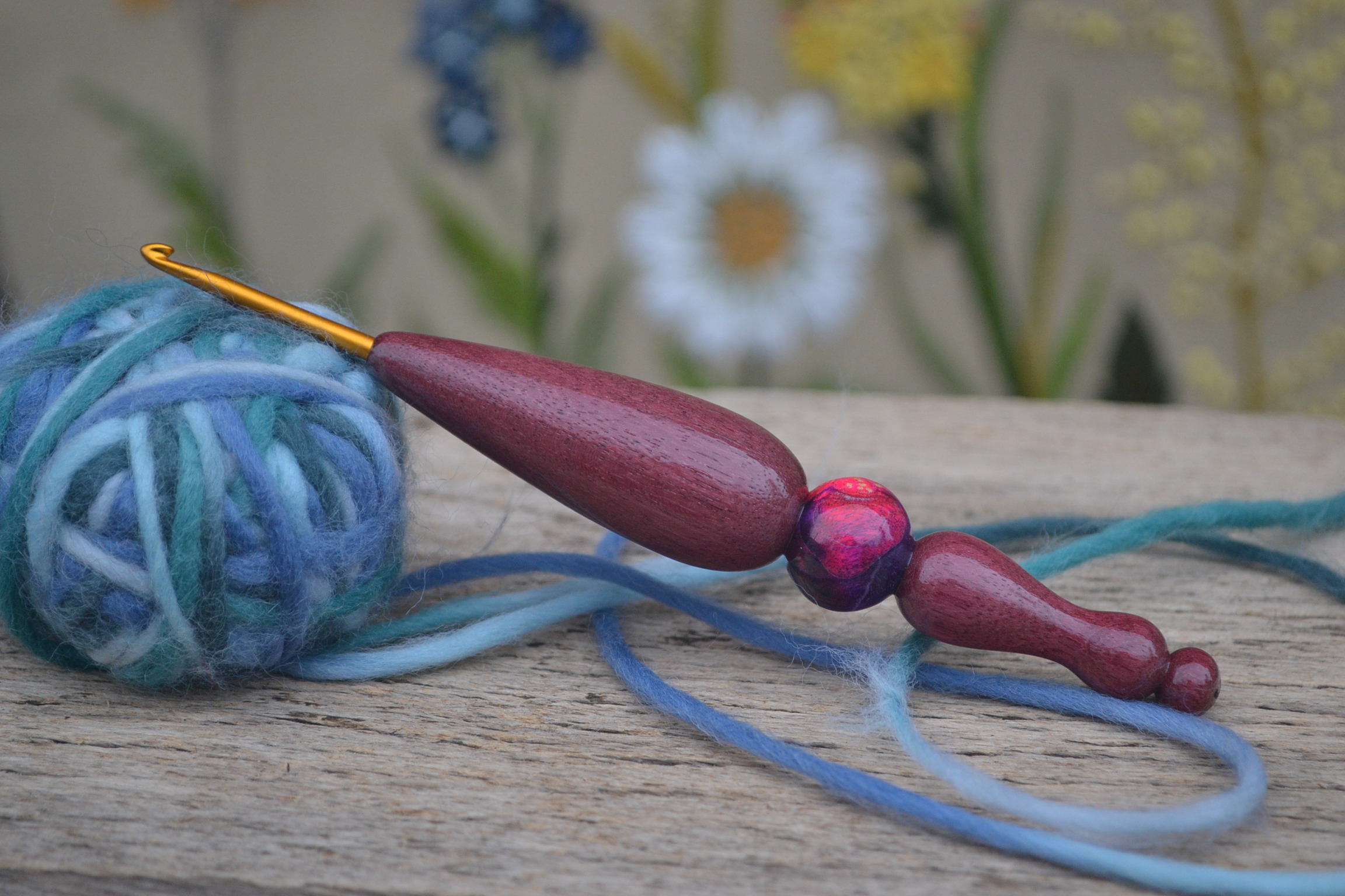Handmade ergonomic crochet hook with Clover Soft Touch tip, featuring a stabilized maple burl sphere inlay and Purpleheart wood handle, reinforced with a metal rod.