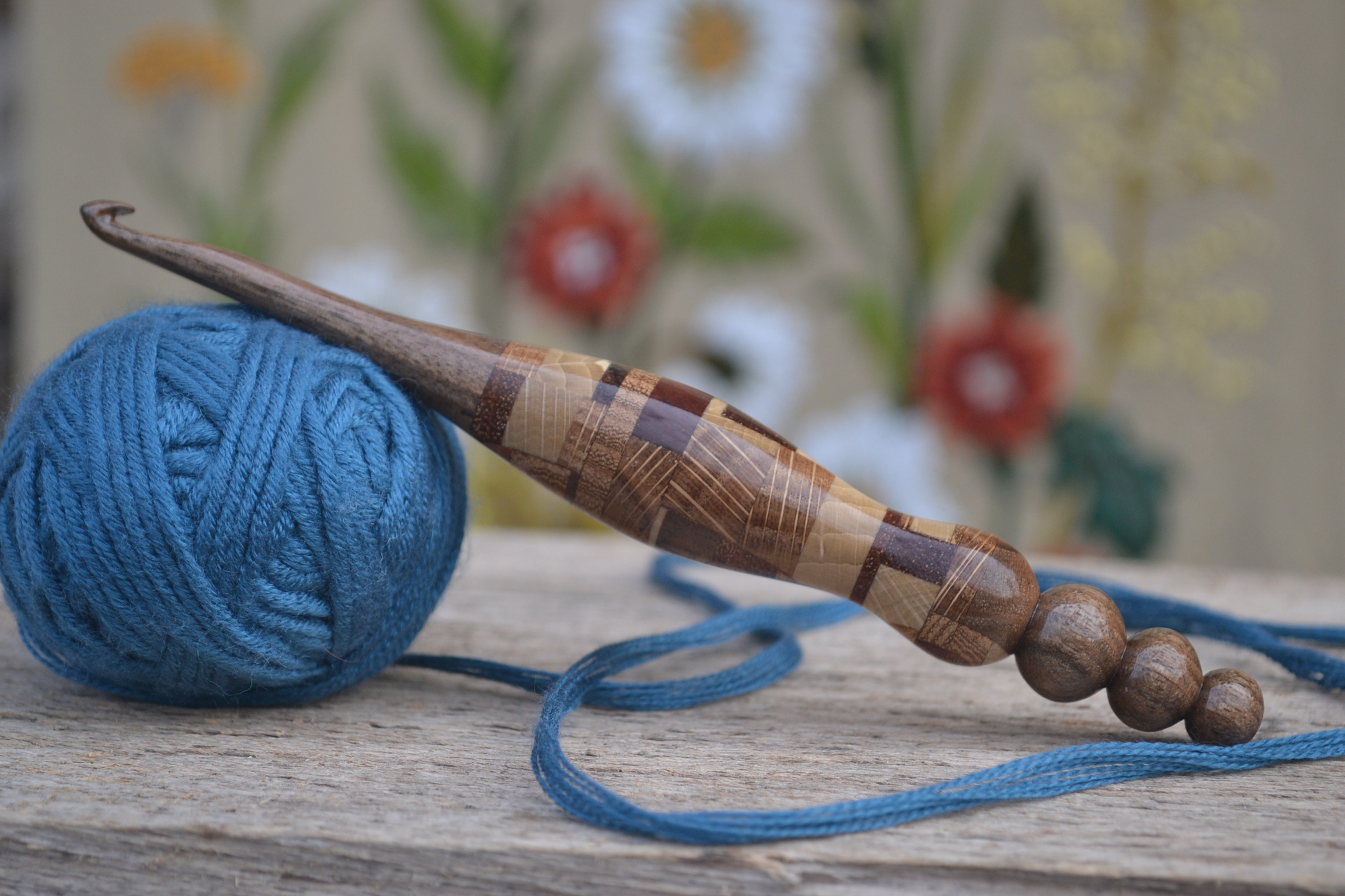 Handmade 6mm wooden crochet hook with a patchwork handle, reinforced with a metal rod.