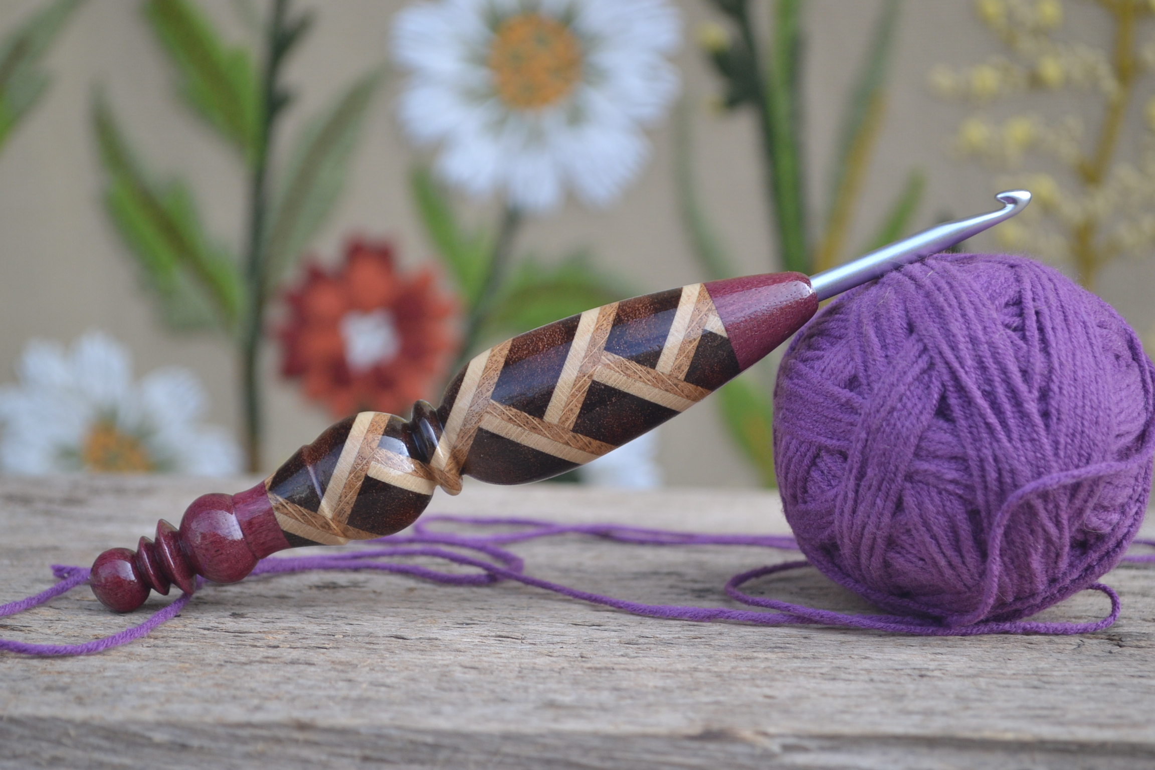 Wooden ergonomic crochet hook with Clover Amour metal tip, laminated handle of merbau, hornbeam, and oak, ends in amaranth.